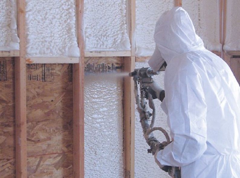 A FoamTech contractor applying spray foam insulation in a RVA garage